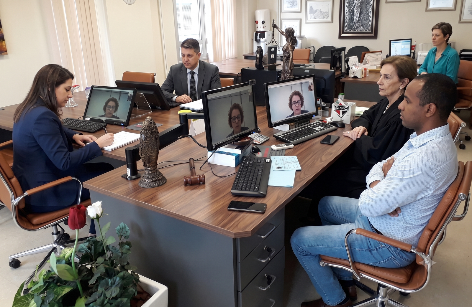 Sala de audiência com advogados e participantes durante uma audiência