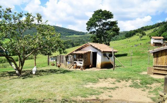 foto de pequena propriedade rural em atividade, com area de cultivo ou pastagem, cercas e estrada de terra, ilustrando a penhora de pequena 