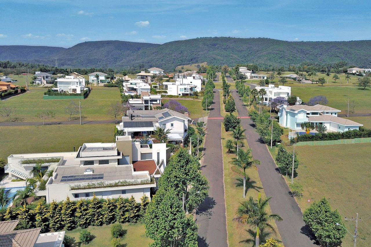 imagem sugerida: terreno urbano vazio em bairro valorizado, com placa de vende-se, luz de fim de tarde, tons escuros