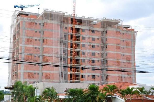 imagem sugerida: fachada de edificio residencial em construcao em aracaju, com guindaste, luz de fim de tarde