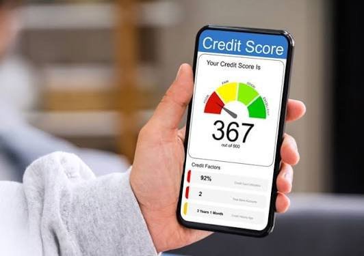 imagem sugerida: foto nova de pessoa segurando o celular e olhando com duvida a tela de um aplicativo de consulta de score ou de biro de cre